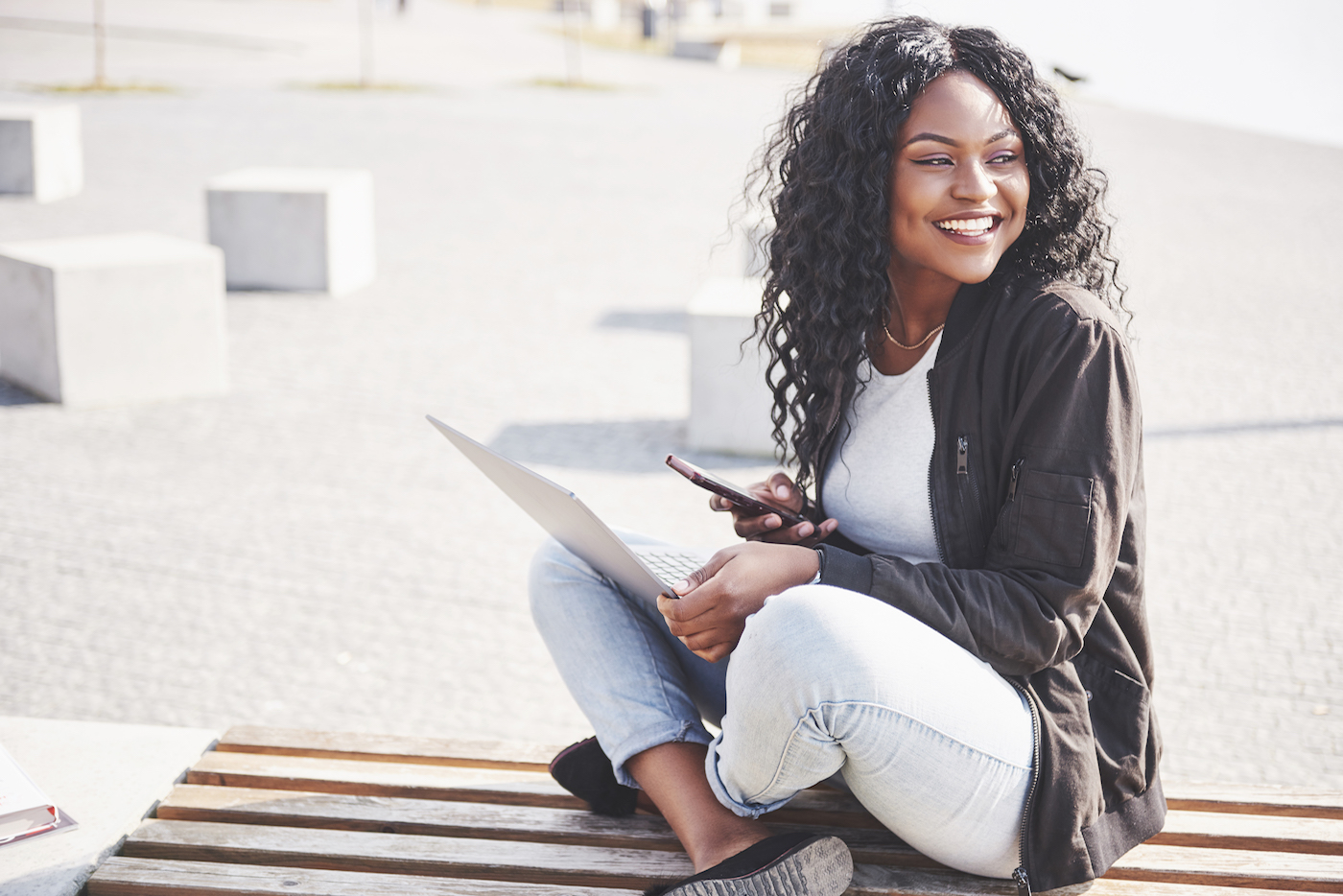 woman sitting on sidewalk smiling