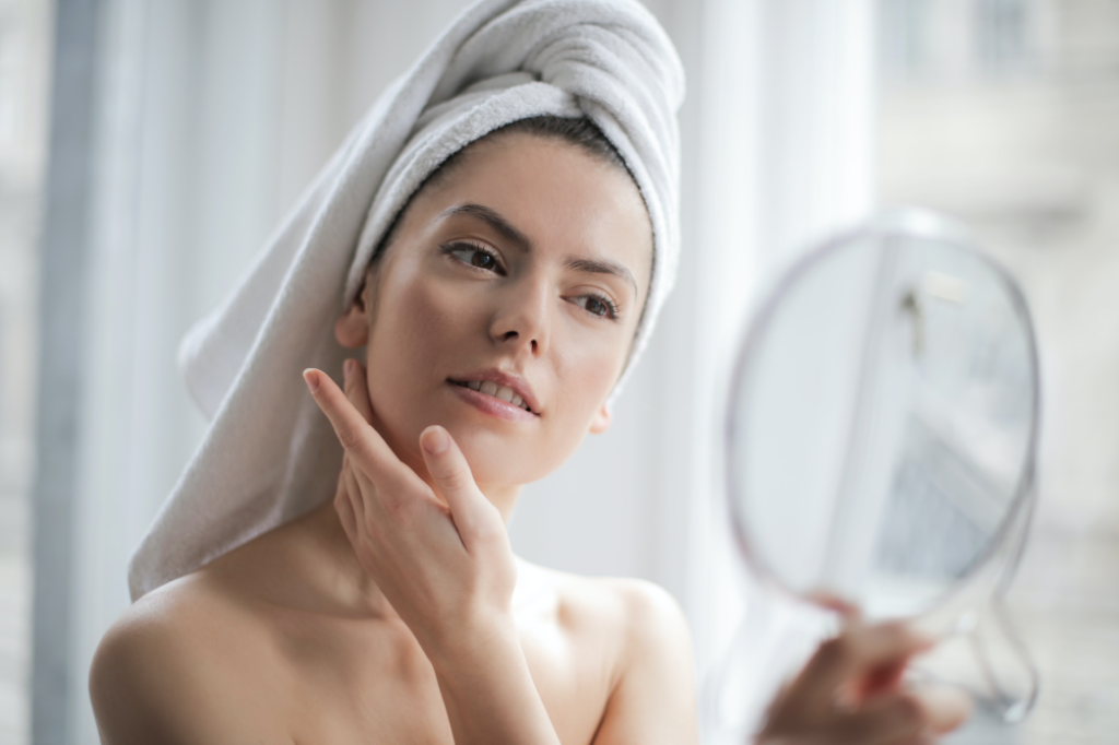 woman looking at face in mirror