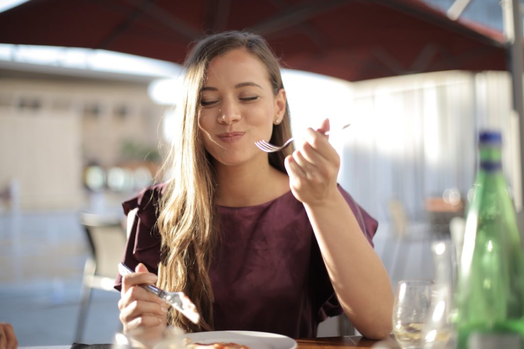 woman smiling while eating