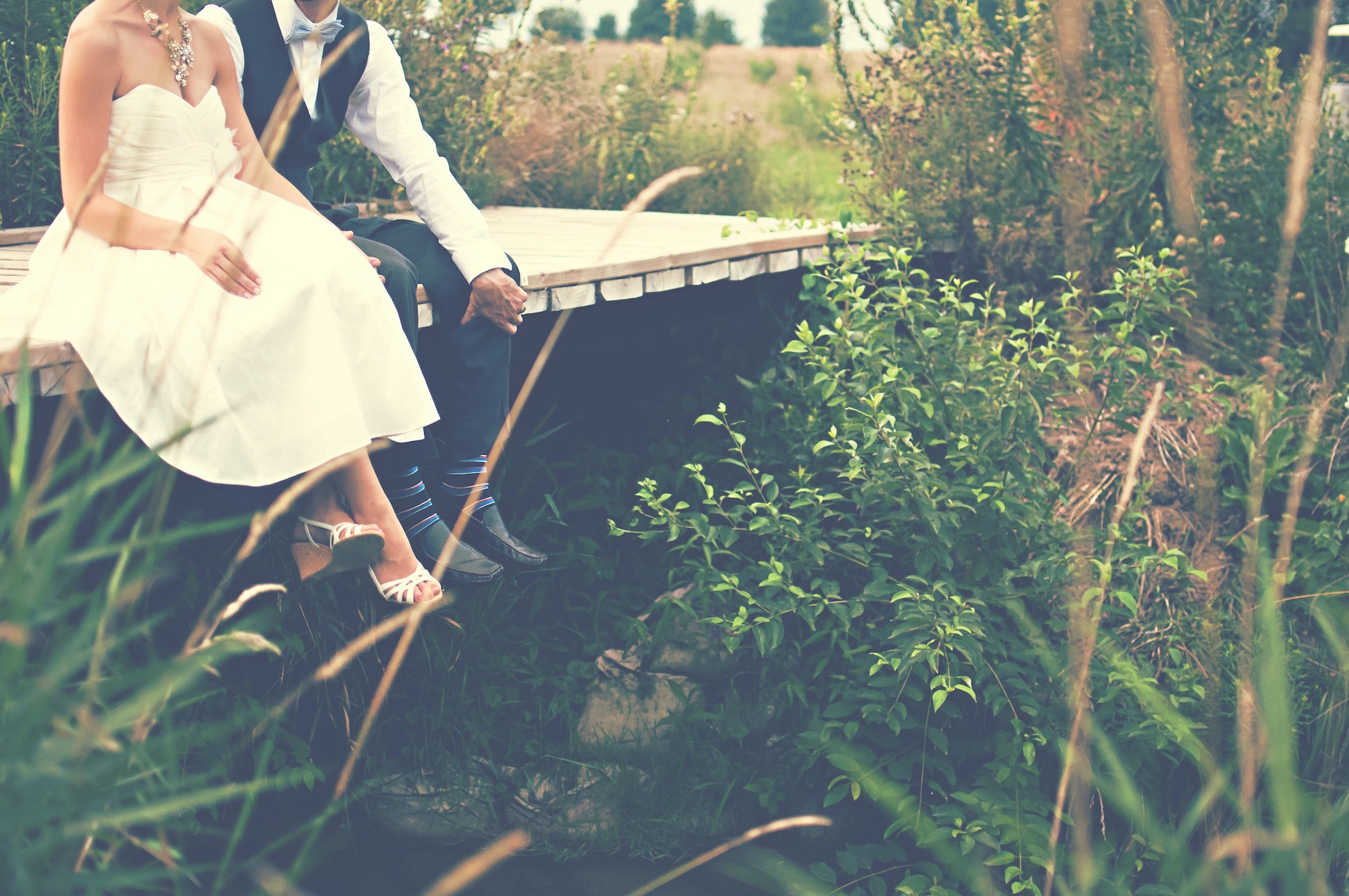 wedding couple sitting on dock