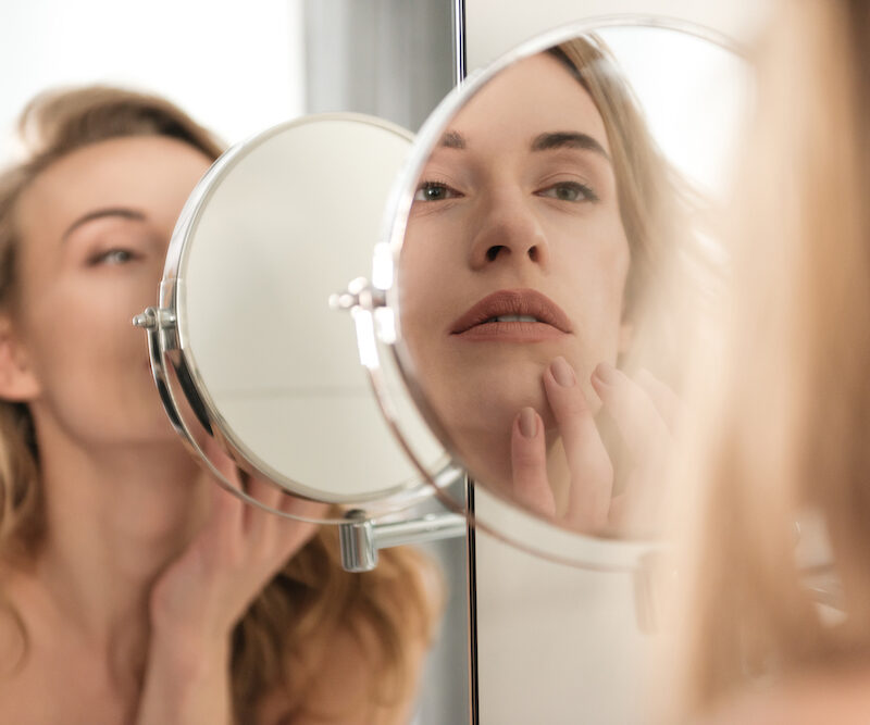 young blonde woman looking at reflections after sculptra in Oklahoma City